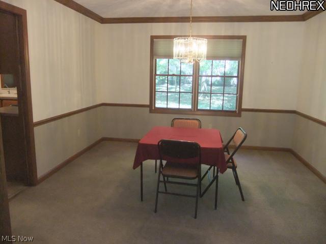 4601 Pinewood Path Akron, OH 44321 - Photo 7 of 23 The formal dining room features neutral carpet and walls, chair rail trim and crown molding.