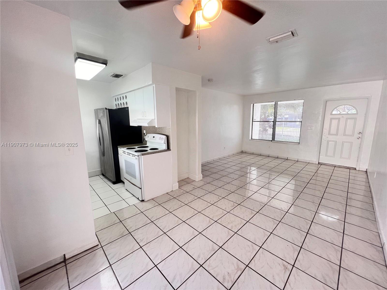 10005 Southwest 214th Street, Unit 10005 Cutler Bay, FL 33189 - Photo 11 of 22 a kitchen with granite countertop a sink a stove top oven and cabinets