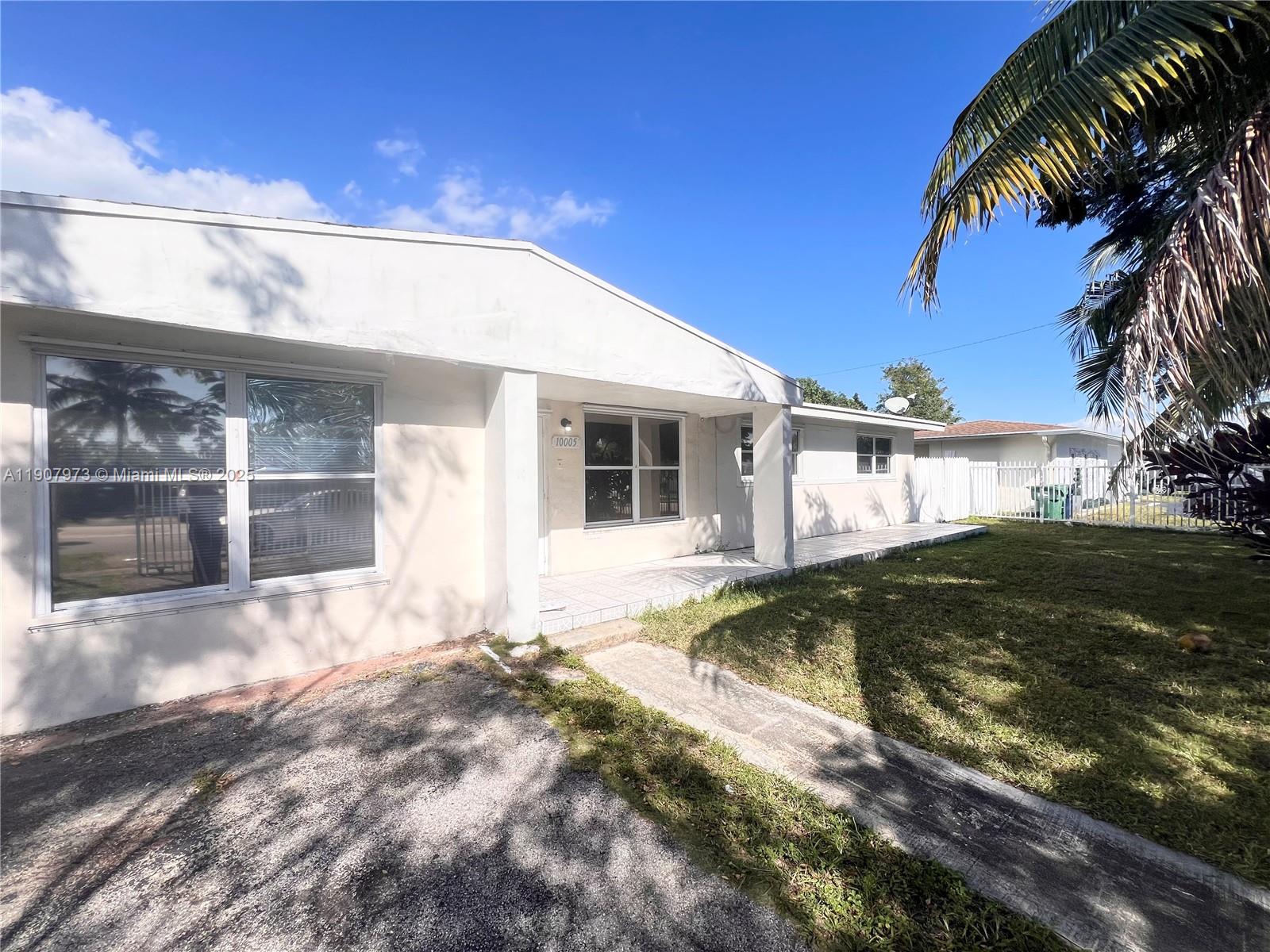 10005 Southwest 214th Street, Unit 10005 Cutler Bay, FL 33189 - Photo 18 of 22 a front view of a house with a yard