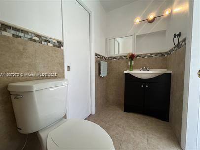 10005 Southwest 214th Street, Unit 10005 Cutler Bay, FL 33189 - Photo 5 of 22 a bathroom with a toilet sink and mirror