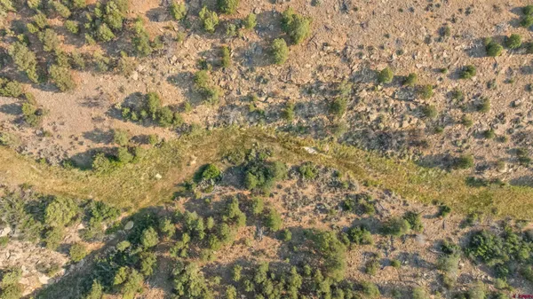 an aerial view of house with yard and mountain view in back