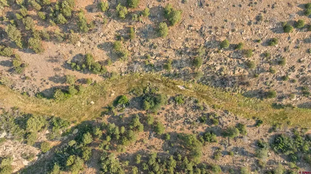 an aerial view of house with yard and mountain view in back