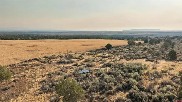 an aerial view of ocean and residential houses with outdoor space