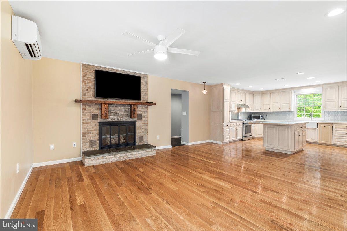 6117 Long Branch Road Frederick, MD 21701 - Photo 15 of 75 a view of a livingroom with a fireplace a flat screen tv and kitchen view