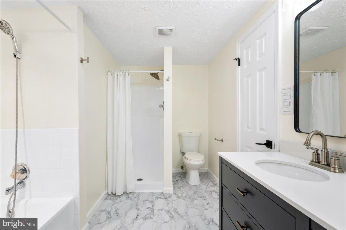 6117 Long Branch Road Frederick, MD 21701 - Photo 24 of 75 a bathroom with a granite countertop sink toilet and shower