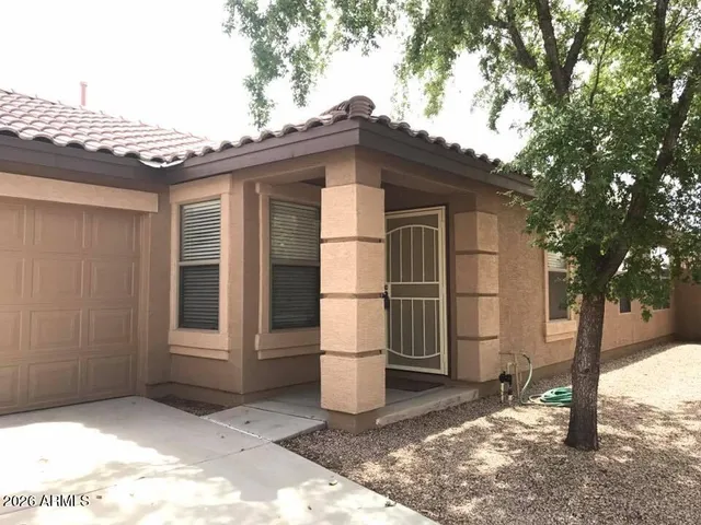 a white house that has tree in front of it