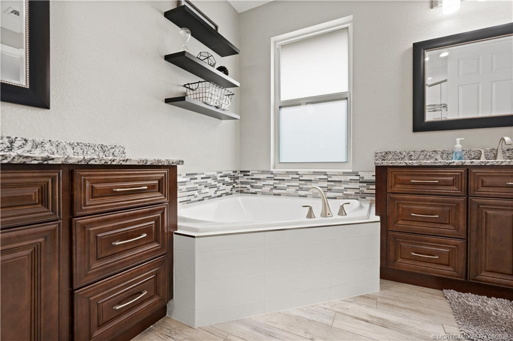 1268 Southeast Kirk Street Stuart, FL 34997 - Photo 38 of 63 a bathroom with a sink a vanity and a mirror