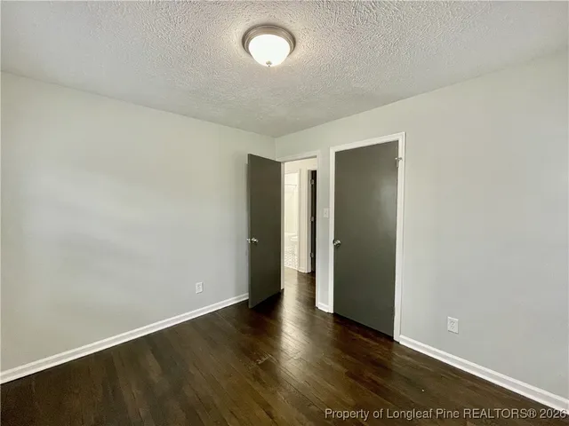 an empty room with wooden floor and closet
