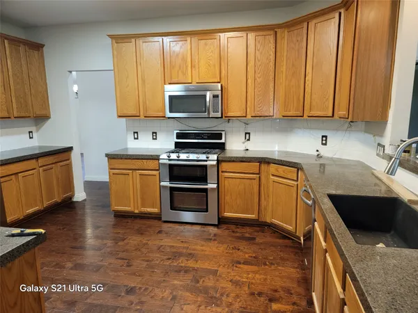 a kitchen with stainless steel appliances granite countertop a stove sink and cabinets