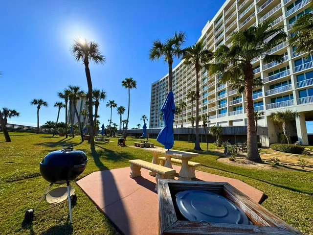 a view of swimming pool with a lounge chair and palm trees