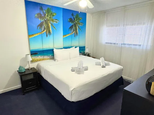 a white bed sitting in a bedroom next to a window