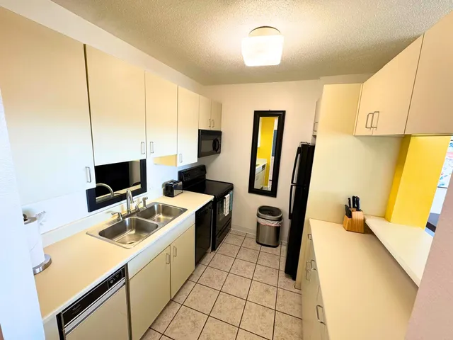 a kitchen that has a sink a stove and a refrigerator