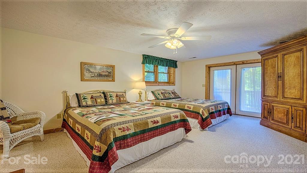49 Sunrise Ridge Maggie Valley, NC 28751 - Photo 22 of 24 a bedroom with a bed and a chandelier
