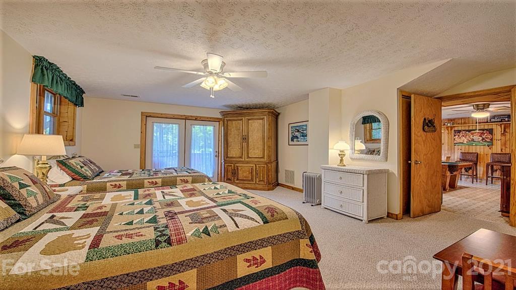 49 Sunrise Ridge Maggie Valley, NC 28751 - Photo 23 of 24 a bedroom with a large bed and a chandelier