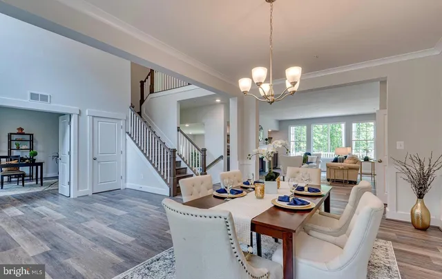 a living room with furniture a chandelier and a dining room