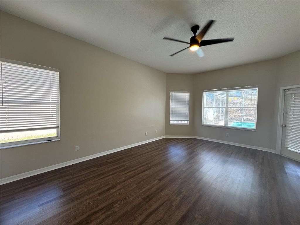 28724 Hanging Moss Loop Wesley Chapel, FL 33543 - Photo 14 of 30 a view of an empty room with wooden floor and a window