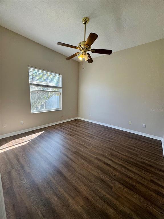 28724 Hanging Moss Loop Wesley Chapel, FL 33543 - Photo 21 of 30 a view of a room with wooden floor and a ceiling fan