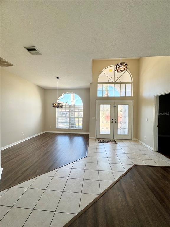 28724 Hanging Moss Loop Wesley Chapel, FL 33543 - Photo 6 of 30 an empty room with wooden floor chandelier and glass door
