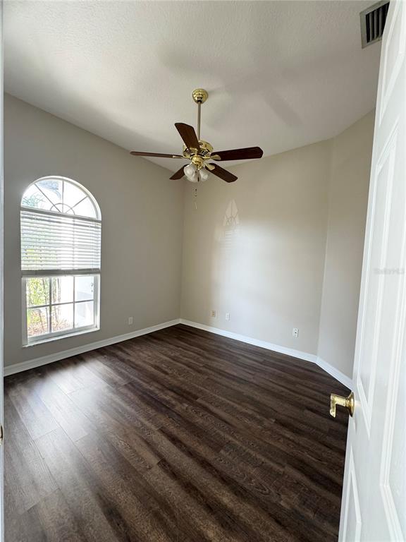 28724 Hanging Moss Loop Wesley Chapel, FL 33543 - Photo 7 of 30 an empty room with wooden floor fan and windows
