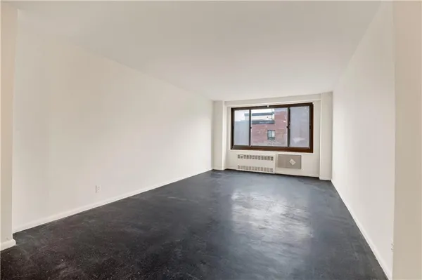 an empty room with windows and cabinet