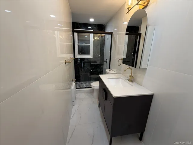 a bathroom with a sink a toilet and mirror