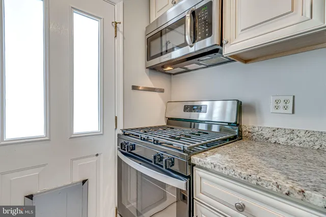 a kitchen with stainless steel appliances granite countertop a sink and dishwasher with wooden floor