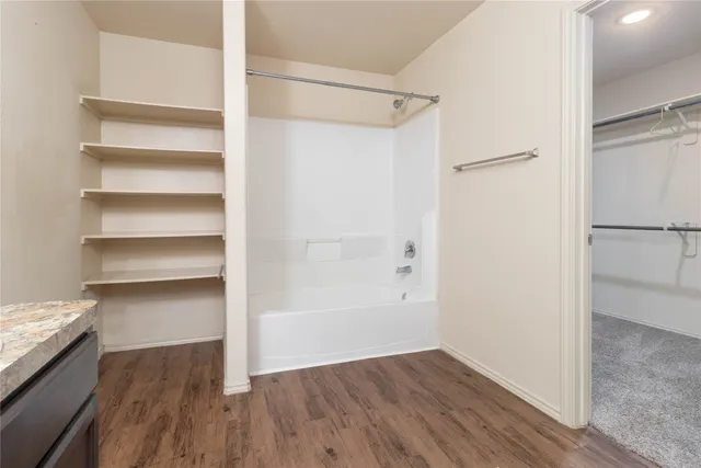 a view of walk in closet with empty racks