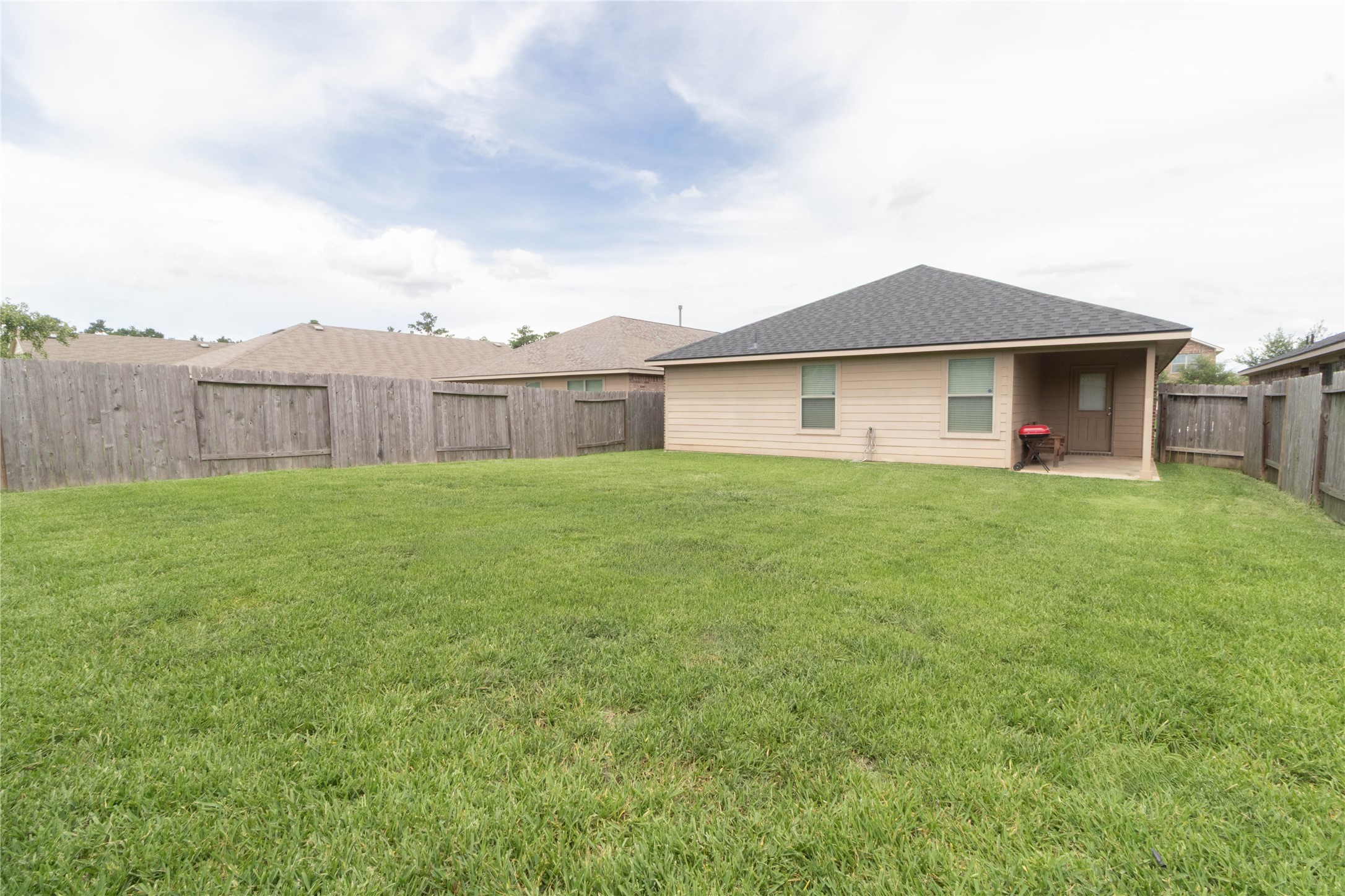24423 Raindrop Poppy Drive Spring, TX 77373 - Photo 25 of 29 a white house with a yard and wooden fence