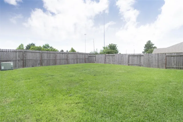 a view of a backyard with a small cabin and wooden fence