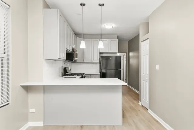 a kitchen with stainless steel appliances a refrigerator sink and microwave