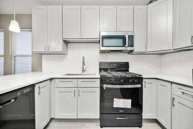 a kitchen with white cabinets and stainless steel appliances
