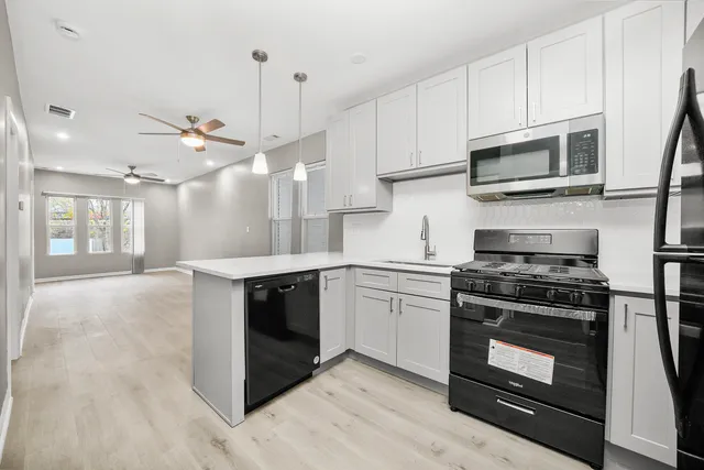 a kitchen with stainless steel appliances granite countertop a stove and a microwave