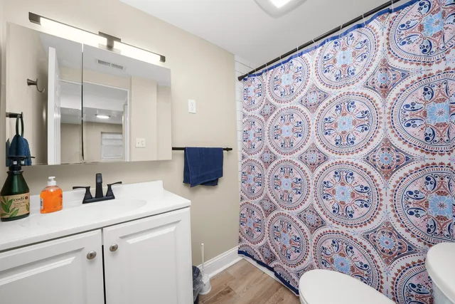a bathroom with a sink toilet and shower curtain
