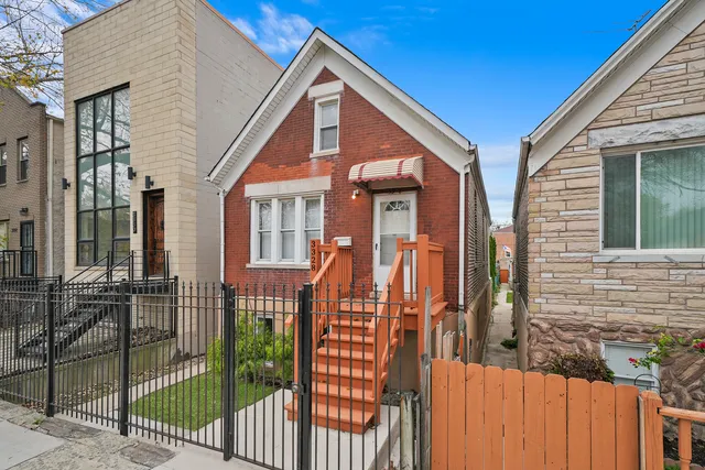a view of a house with wooden fence and two windows