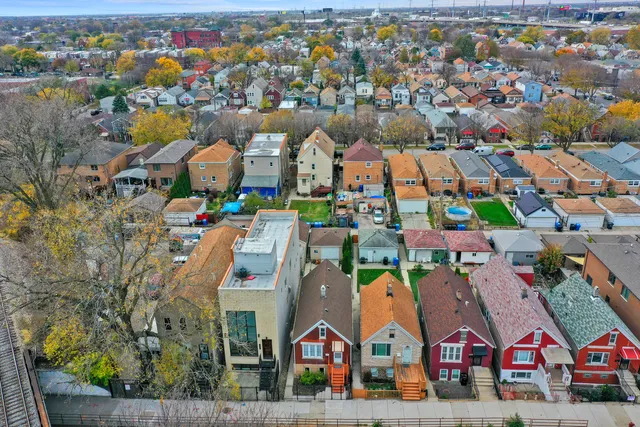 an aerial view of residential houses with outdoor space and parking