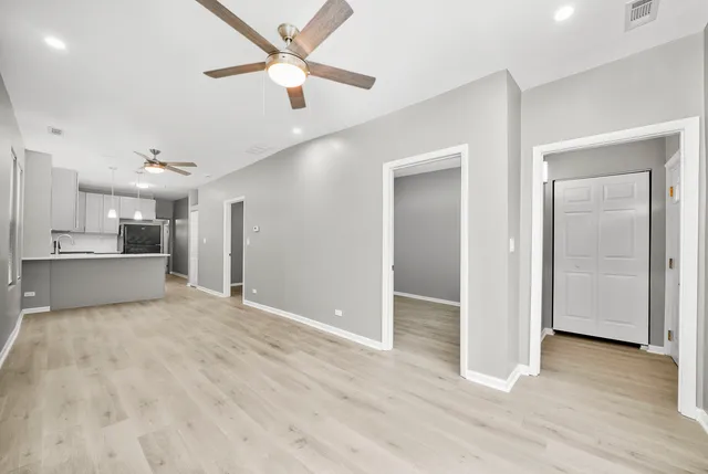 a view of a kitchen with wooden floor and a ceiling fan