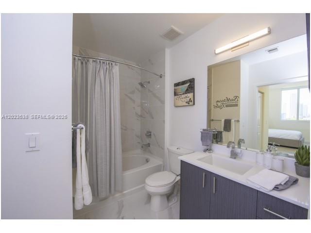 729 Northwest 2nd Street, Unit 920 Miami, FL 33128 - Photo 4 of 9 a bathroom with a sink a toilet a shower and a mirror