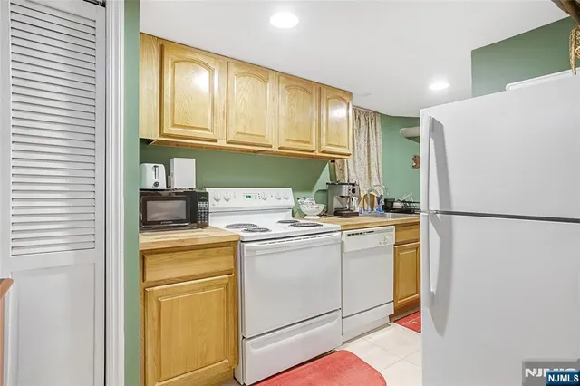 a kitchen with a refrigerator sink and cabinets