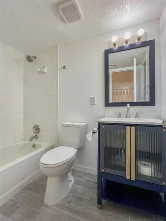 a bathroom with a sink toilet a mirror and bathtub