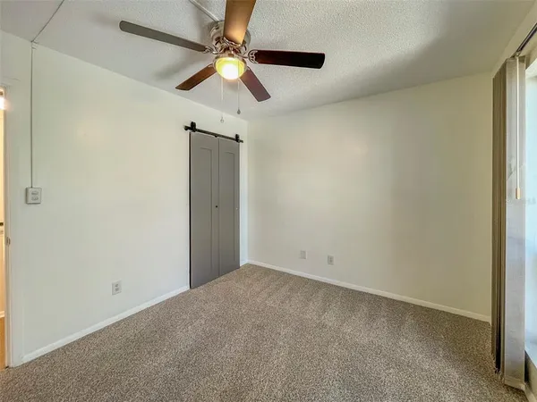 an empty room with a ceiling fan and a window
