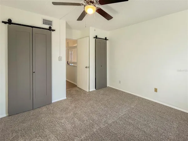 an empty room with a ceiling fan and closet