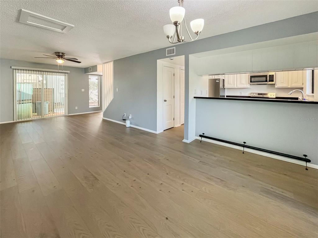 4001 South Beneva Road, Unit 416 Sarasota, FL 34233 - Photo 4 of 19 an empty room with wooden floor and windows