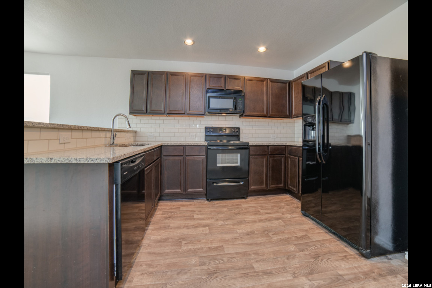 2426 Rainbow Basin Converse, TX 78109 - Photo 6 of 12 a kitchen with stainless steel appliances granite countertop a refrigerator and a sink