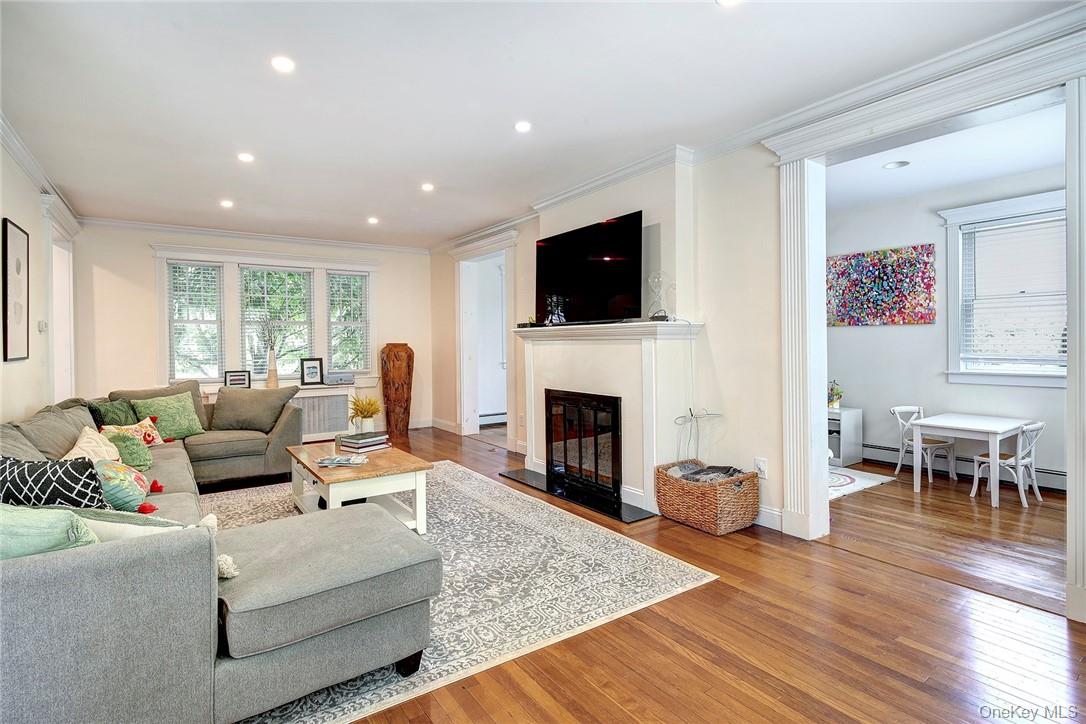 8 Horton Street Rye, NY 10580 - Photo 4 of 24 Living room with hardwood / wood flooring, ornamental molding, a glass covered fireplace, recessed lighting