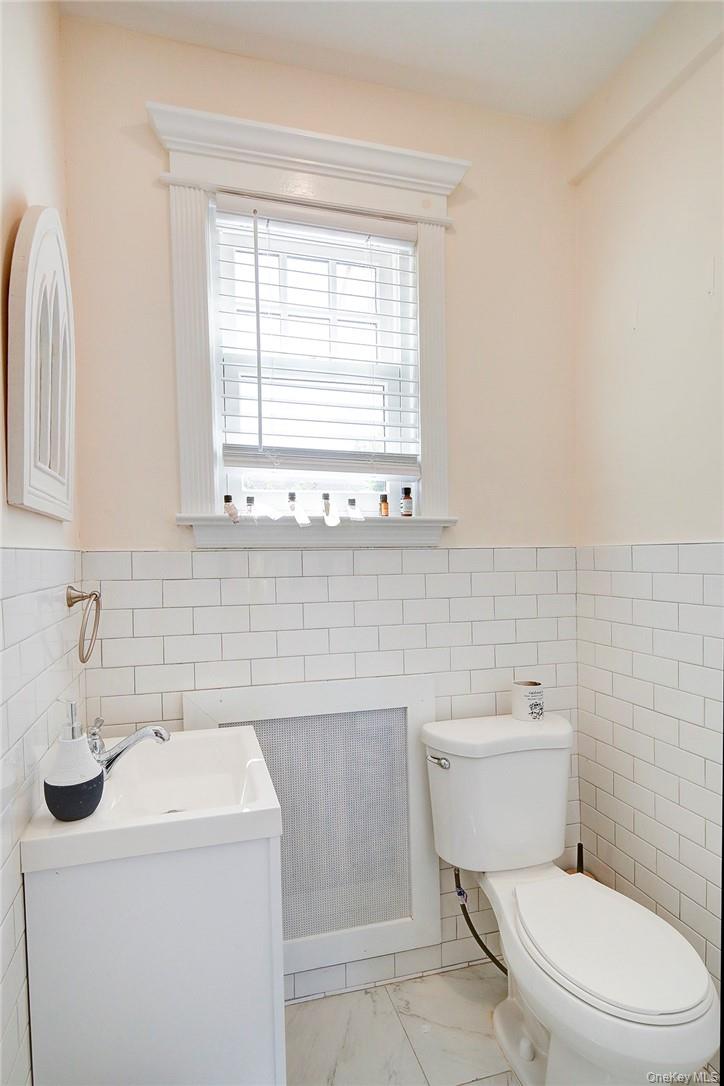 8 Horton Street Rye, NY 10580 - Photo 9 of 24 Updated Powder Room with tile walls, wainscoting, and vanity