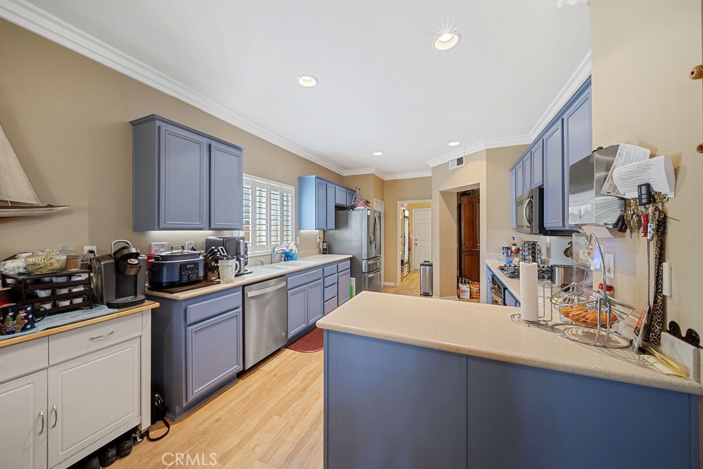 7606 Isla Street Hemet, CA 92545 - Photo 12 of 41 a kitchen with stainless steel appliances a sink stove and cabinets
