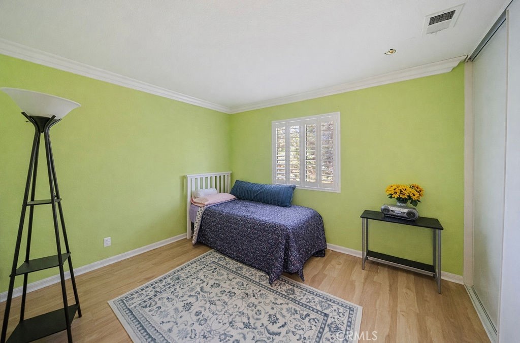 7606 Isla Street Hemet, CA 92545 - Photo 17 of 41 a bedroom with a bed and wooden floor