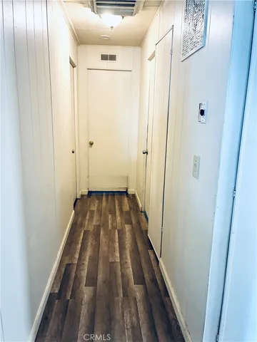 a view of a hallway with wooden floor