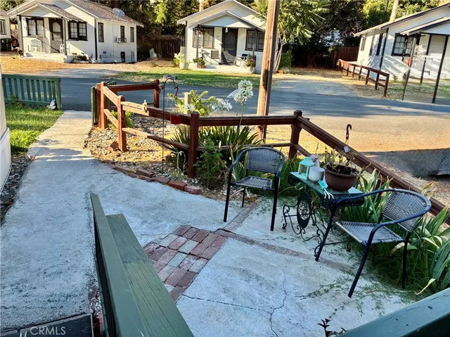 a view of a patio with table and chairs with wooden floor and fence