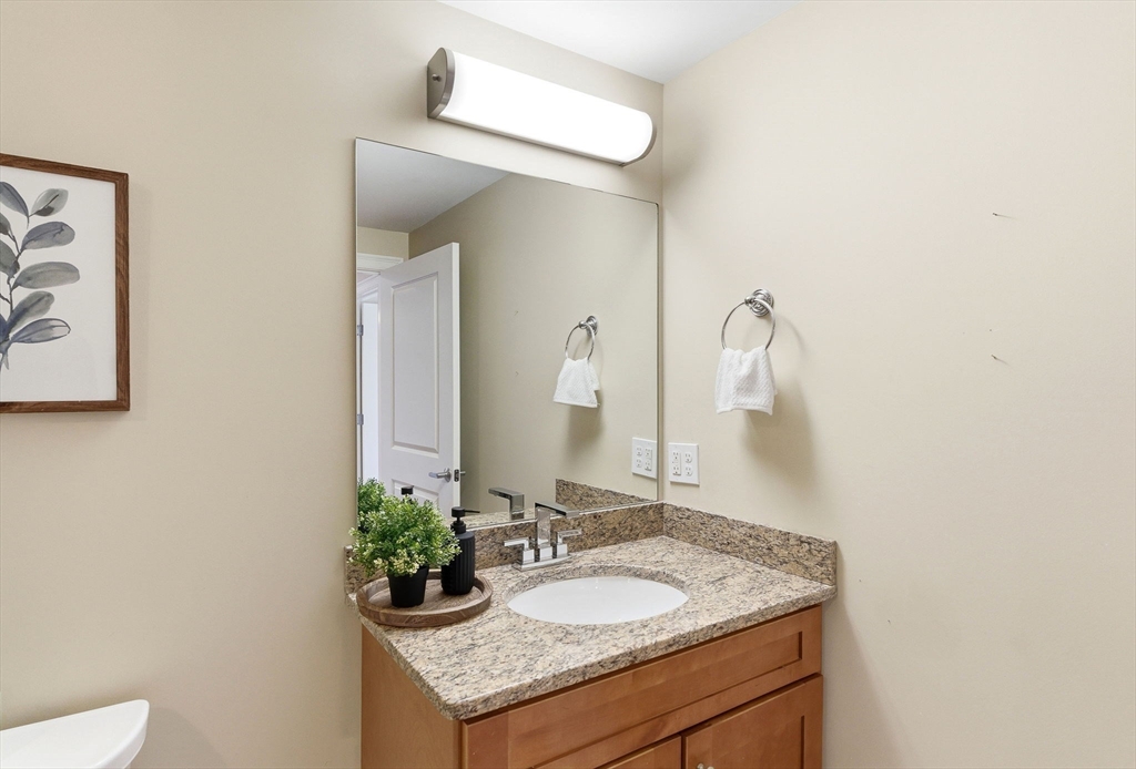 70 Great Road, Unit G Bedford, MA 01730 - Photo 13 of 15 a bathroom with a granite countertop sink and a mirror